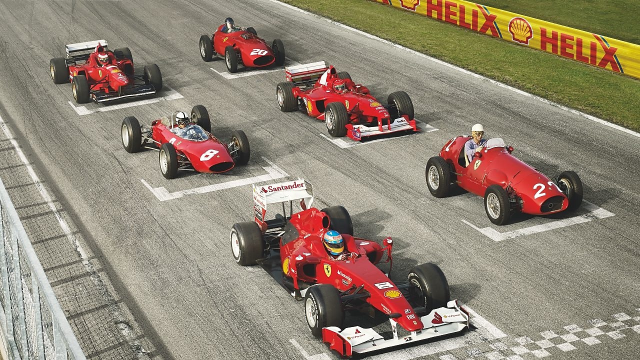 Collection of red ferrari cars on starting grid