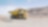 yellow dumper truck driving through gravel