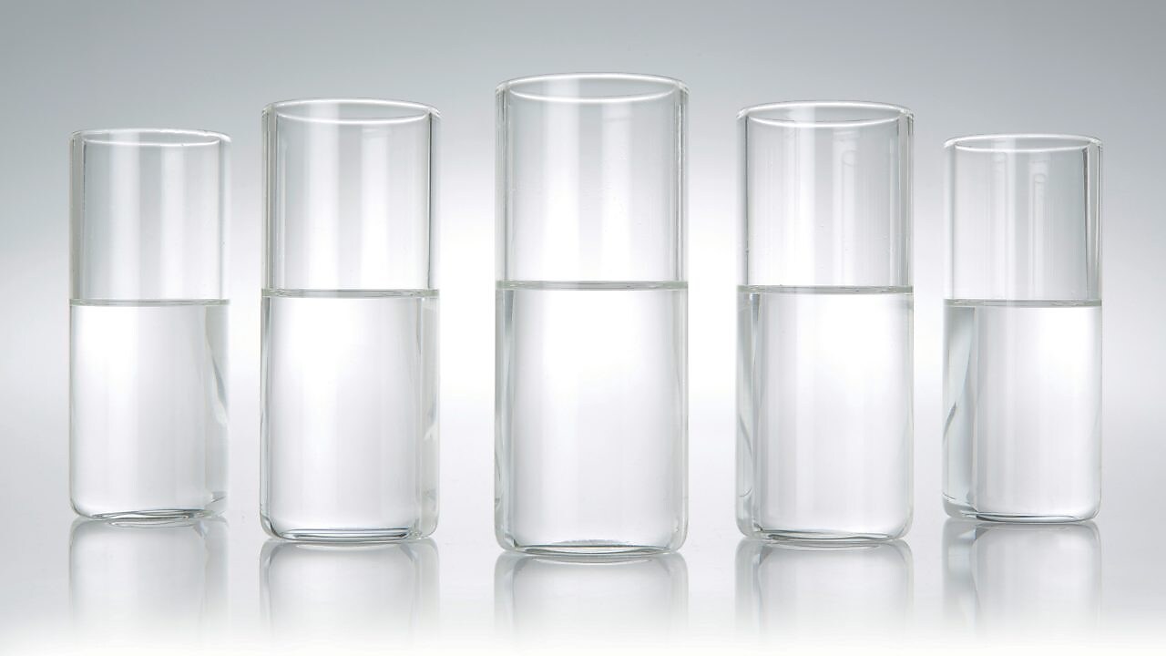 Five beakers in a row with a clear liquid in each one