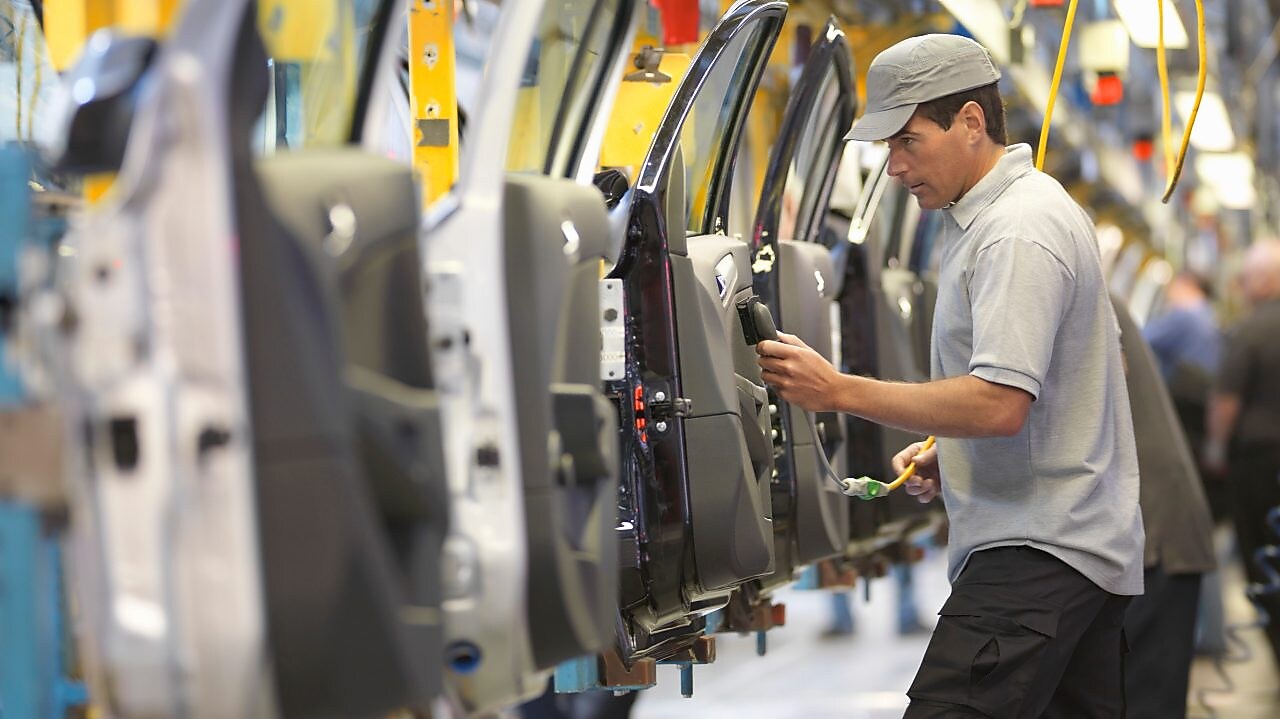 man holding wire looking at machine