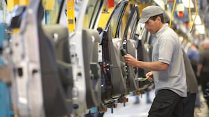 man holding wire looking at machine