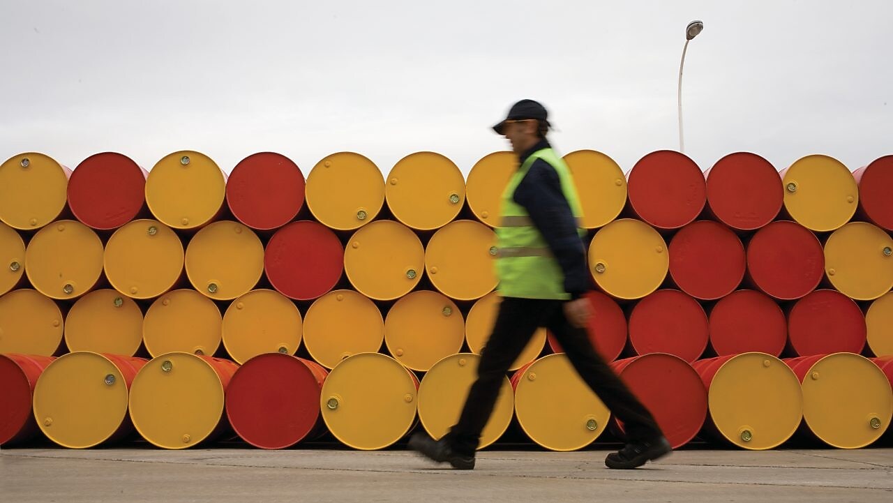 man walking barrels lubricants