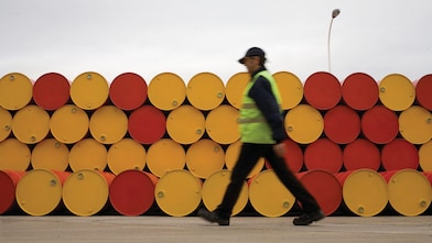 man walking barrels lubricants