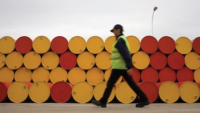 Man walking barrels lubricants