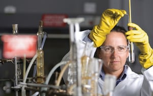 lady in safety goggles conducting a lab experiment