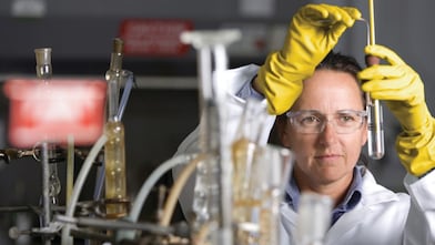 lady in safety goggles conducting a lab experiment