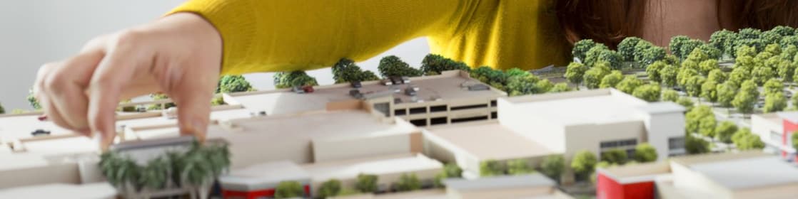 Caucasian businesswoman examining scale model