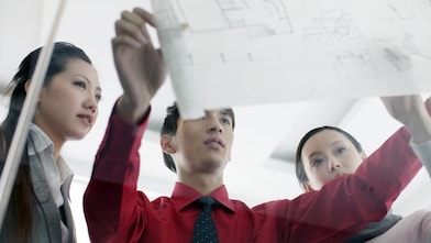 man showing bluprint to colleagues