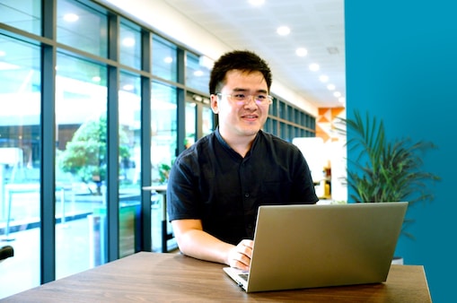 Heng working on his laptop at office