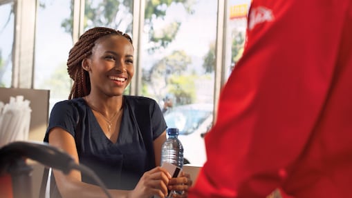 Female customer smiling at a Shell retail station.