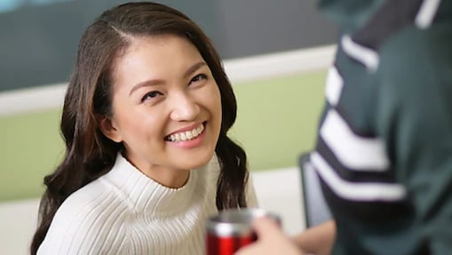 Female Shell employee looking up at a colleague and smiling.