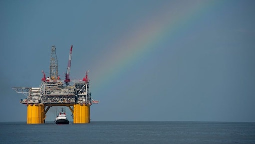 A Shell offshore rig with a rainbow in the background.