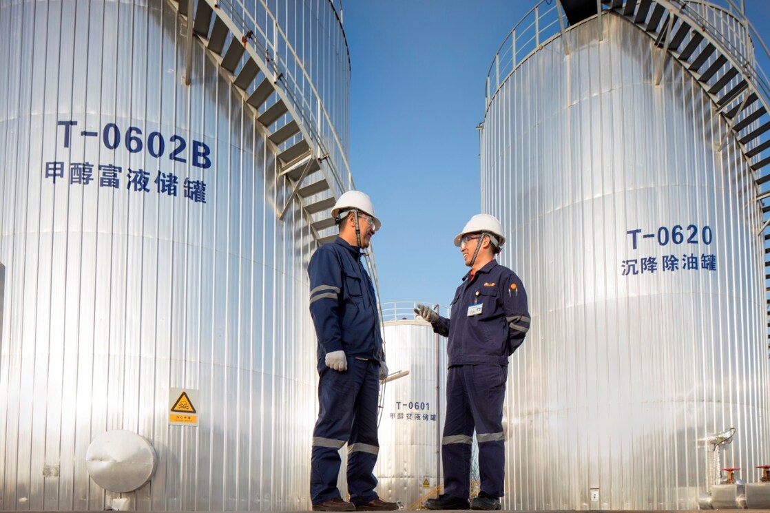 Two Asian Shell engineers meeting at an operational site.