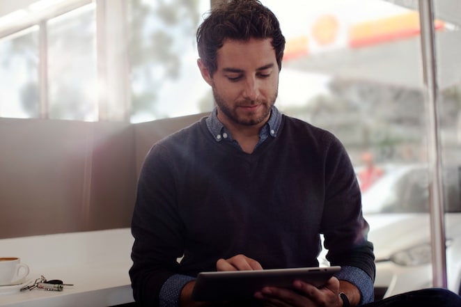 a man busy with tablet holded on his hand