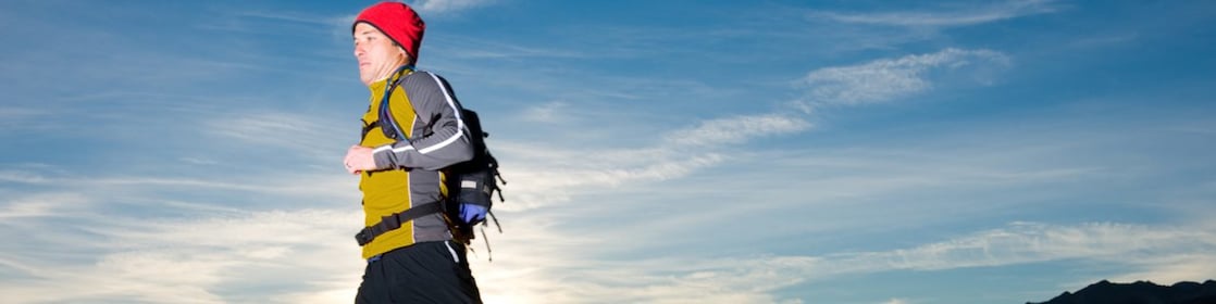 man with prosthetic leg, in running clothes, running in the hills in the early morning