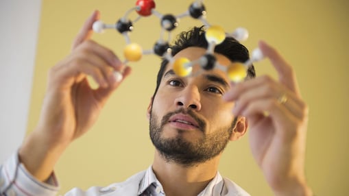 Young man examining molecular model