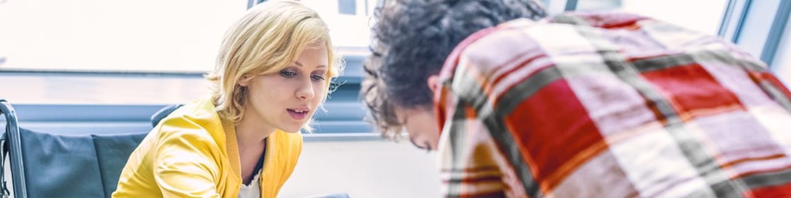 Woman in a wheelchair talking to a man