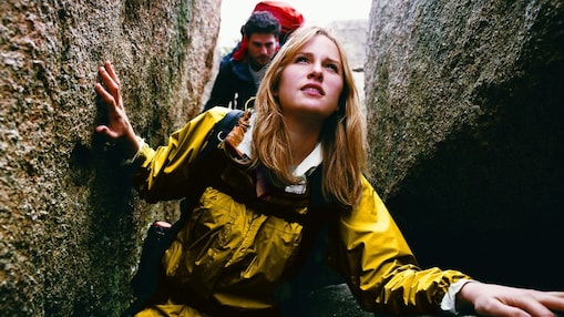 Two young people hiking through a narrow ravine