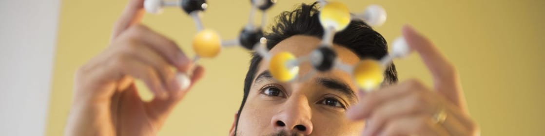 Young man examining molecular model