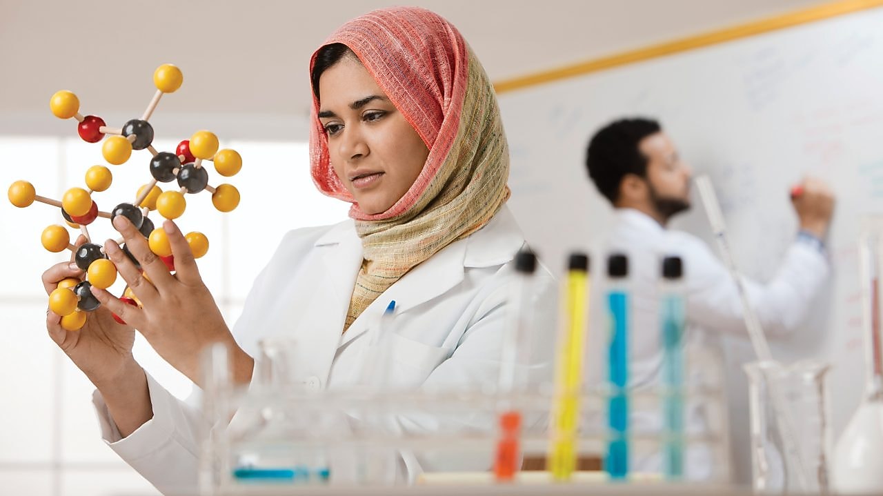 Young female scientist examining a molecular model