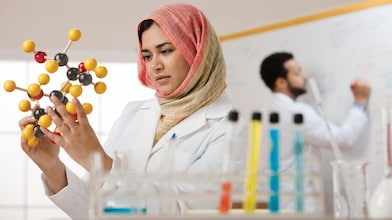 Young female scientist examining a molecular model