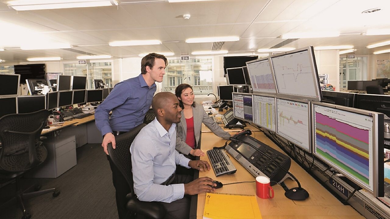 Staff on the Trading Floor examine data on multi computer screens