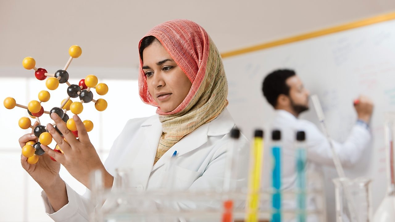 Young female scientist examining a molecular model