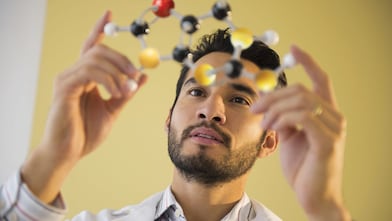 Young man examining molecular model