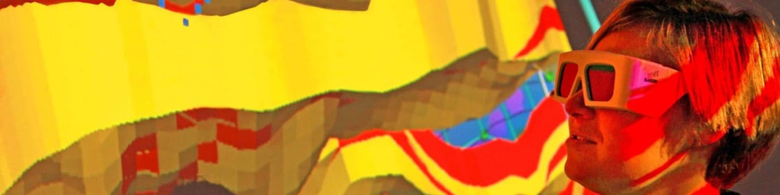 A woman with special goggles examines a 3D wall projection of a geological map 