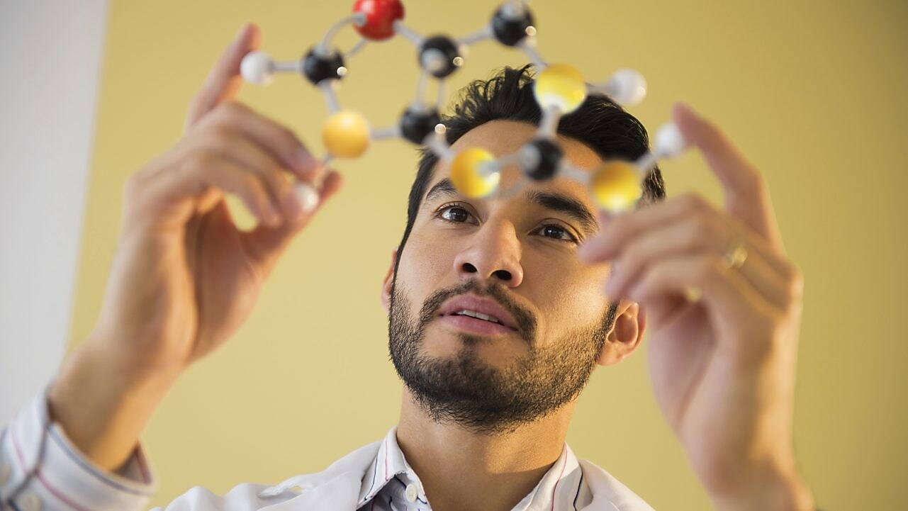 Young man examining molecular model