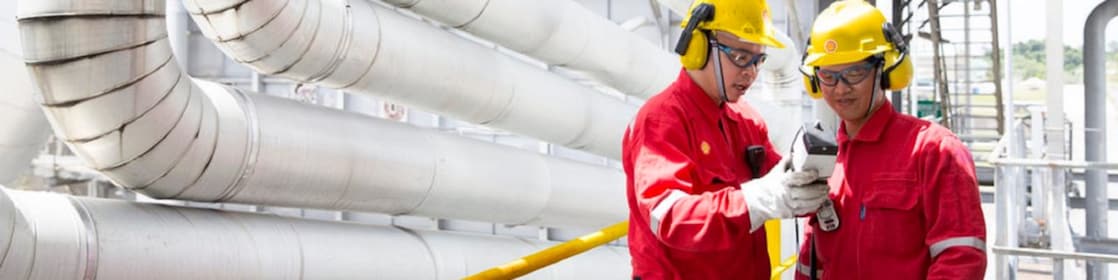 Two engineers looking at equipment in hand