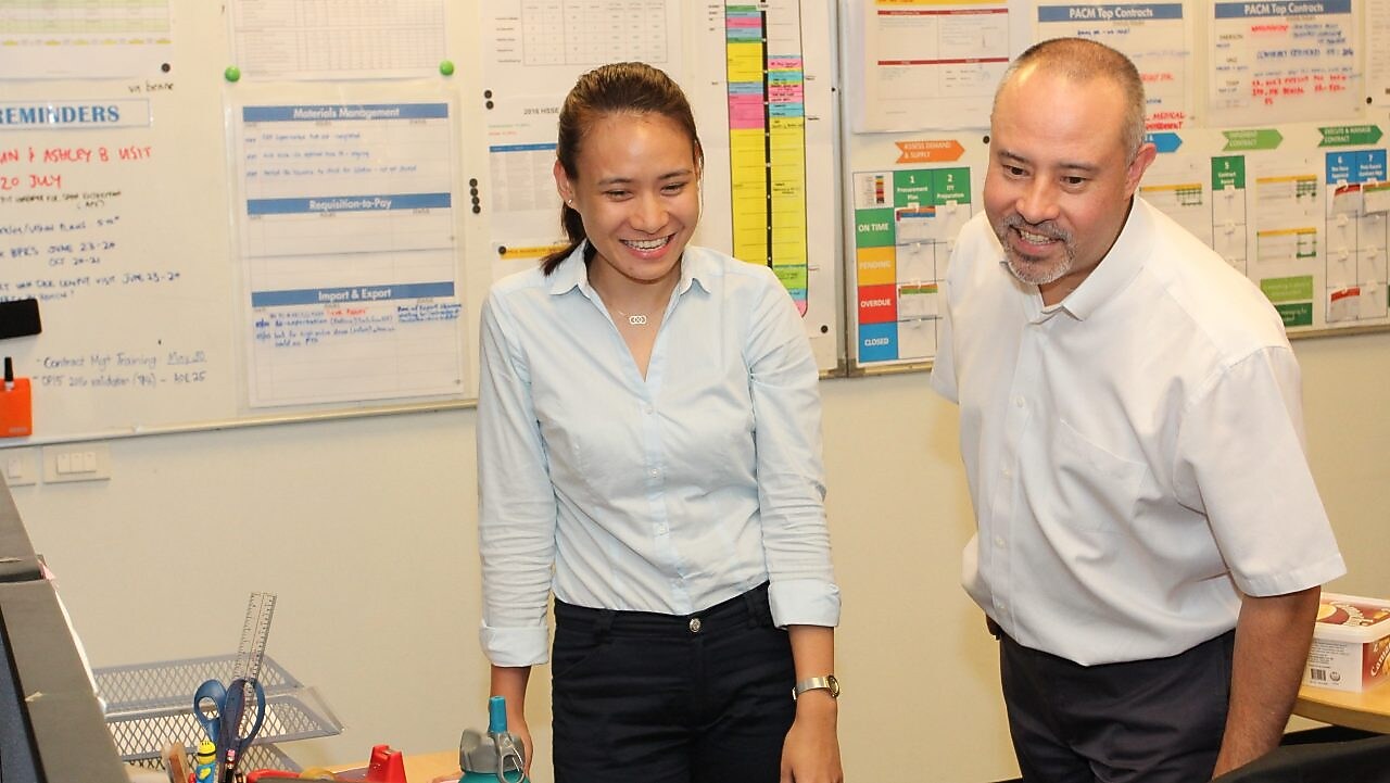 Shell mentor Scott Low with graduate Inah Felisse Margaja looking at a computer monitor