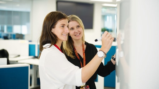 Shell Graduate Samantha Palmer writing on a whiteboard, having a discussion with her mentor Elise-Anne Muir
