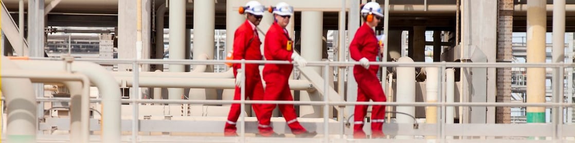 Shell workers walking across the pipe track