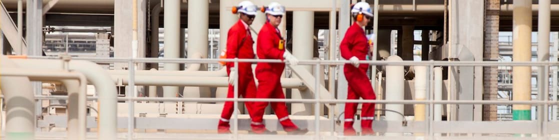Shell workers walking across the pipe track
