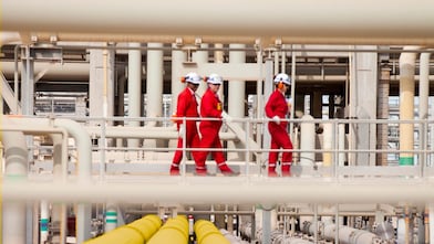 Shell workers walking across the pipe track