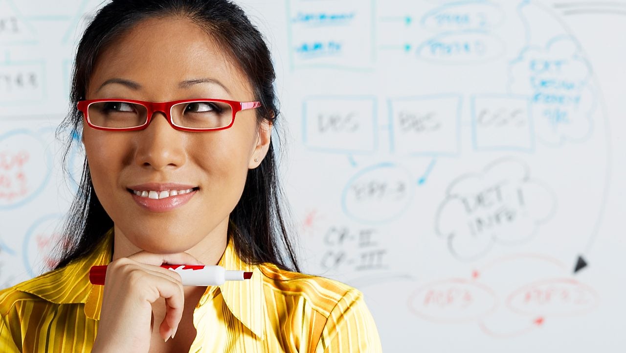 Close up of Asian businesswoman smiling in front of whiteboard