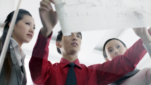 Graduates discussing design plans at work