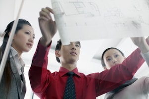 Graduates discussing design plans at work