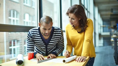 Two architects discussing project at high table