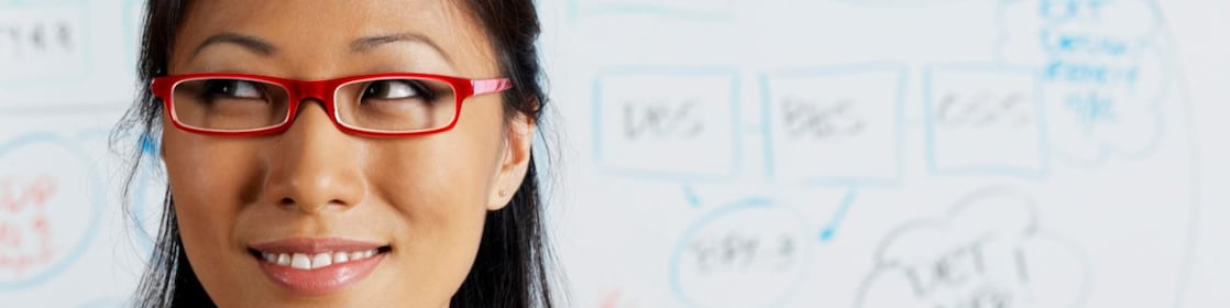 Close up of Asian businesswoman smiling in front of whiteboard