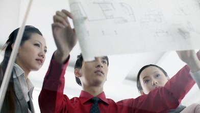 Graduates discussing design plans at work