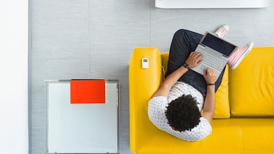 A man sitting on a sofa with his laptop
