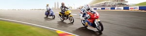 Three different types of motorbike riding round a racing track