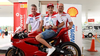 Ducati superbike with seated rider and tech team