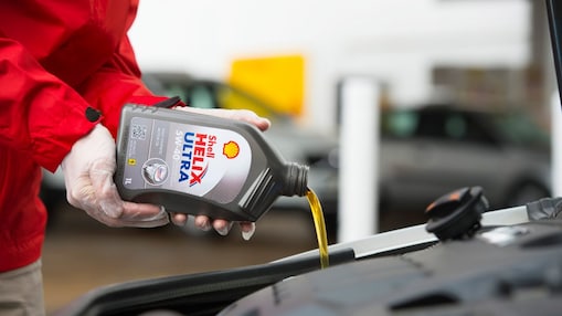 person pouring shell helix ultra in engine