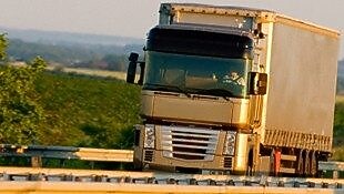 Truck driving on highway, green country background