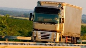 Truck driving on highway, green country background