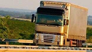 Truck driving on highway, green country background
