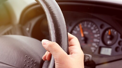 Hand holding a steering wheel